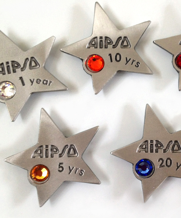 A collection of gleaming pewter stars, each engraved with years of service and adorned with a unique colored gemstone.