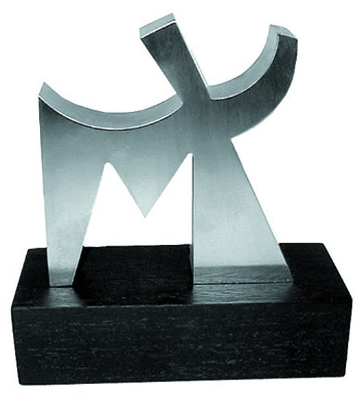 A 6” polished stainless steel abstract “M” sculpture mounted on a black wooden stand